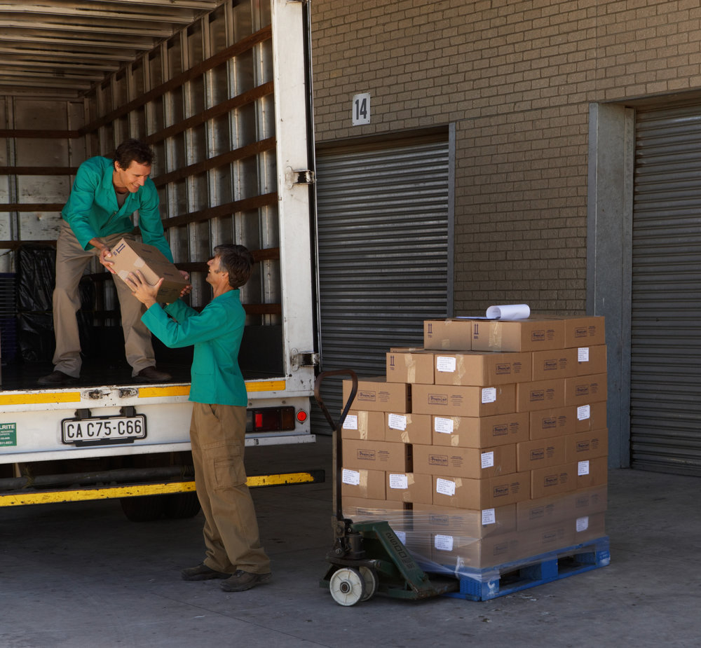 Two men loading boxes into lorry from pallet