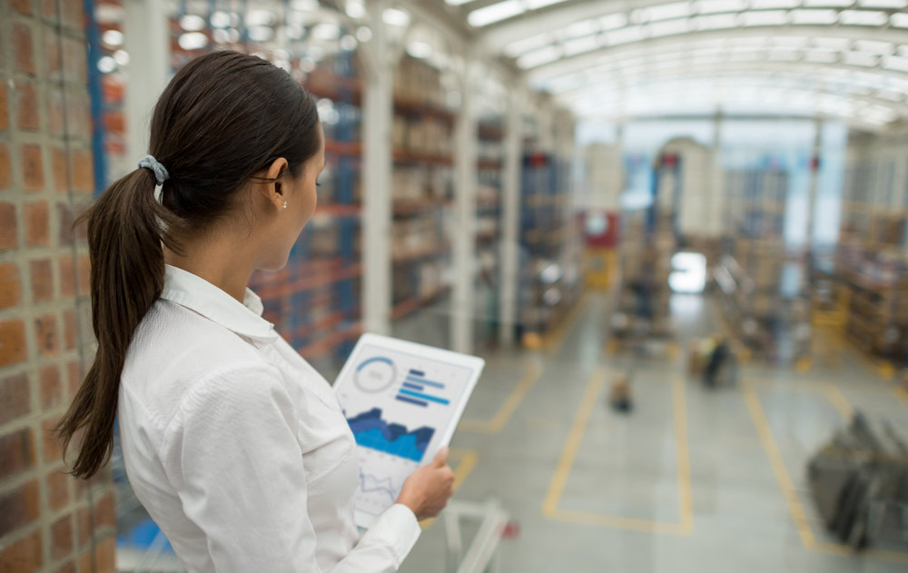 Business woman working on freight transportation and using a tablet computer to check stock at a warehouse