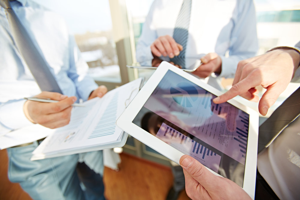 Three managers analyzing financial statistics