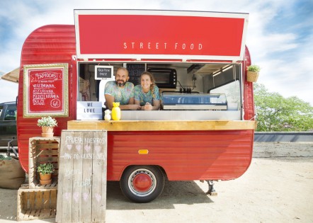 Red food truck and owners, a young couple..