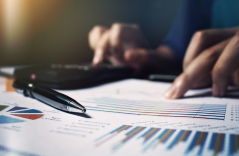 Close up pen on paperwork and woman hand calculate finance.