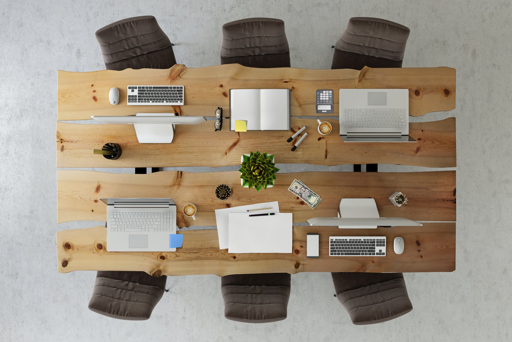 Business group scene showing overhead office desk with multiple chairs around, corporate teamwork template. laptop, tablet, PC computer monitor keyboard, notepad, paper, black chairs around. no people