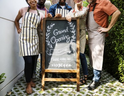 Diverse People with Grand Opening Sign First Day of Business